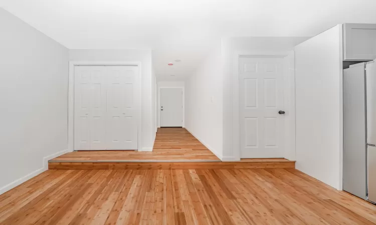 Additional living space featuring baseboards and light wood finished floors