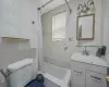 Full bathroom with shower / tub combo with curtain, toilet, tile walls, and vanity