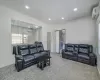 Carpeted living room featuring recessed lighting, baseboards, and a wall mounted AC