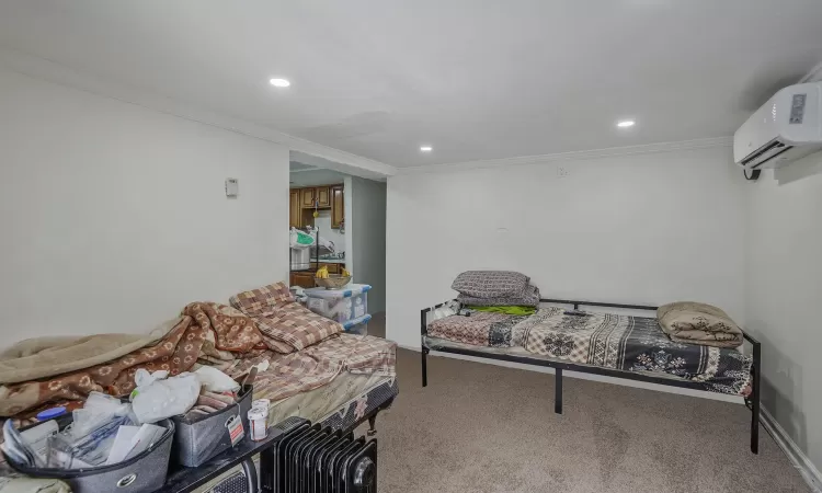 Carpeted bedroom featuring recessed lighting, baseboards, a wall unit AC, and ornamental molding