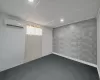 Spare room with a wall unit AC, baseboards, and carpet floors