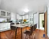 Kitchen with a kitchen breakfast bar, dark wood-style floors, glass insert cabinets, and white cabinets