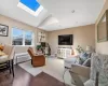 Living room with wood finished floors, a wall mounted AC, recessed lighting, and lofted ceiling with skylight