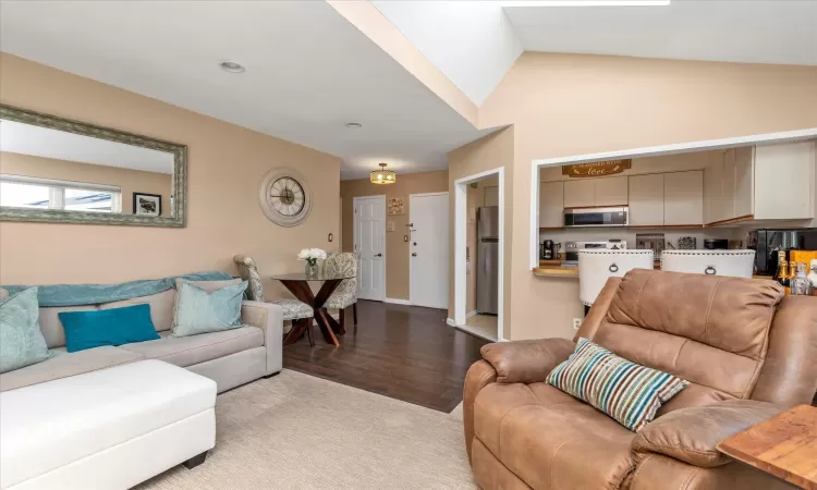 Living room with wood finished floors and vaulted ceiling