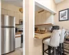 Kitchen with a breakfast bar,  appliances with stainless steel finishes, light tile patterned flooring, and light countertops