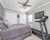 Bedroom featuring two closets, ceiling fan, crown molding, and a wall unit AC