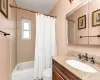 Full bathroom with toilet, vanity, and shower / bath combo