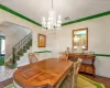 Dining area with  arched walkways, wood finished floors, and crown molding