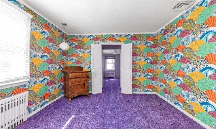 Bedroom featuring  crown molding, radiator heating unit, and carpet floors