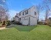 View of side of property with brick siding, a lawn, driveway, and a chimney