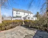 Back of property featuring brick siding and roof with shingles