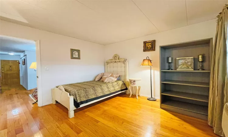 Bedroom with baseboards and wood-type flooring