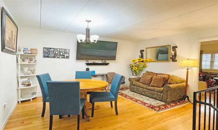 Dining space featuring a notable chandelier, baseboards, and wood finished floors