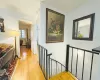 Corridor featuring an upstairs landing and light wood-type flooring