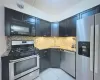 Kitchen with a sink, visible vents, light stone countertops, and appliances with stainless steel finishes