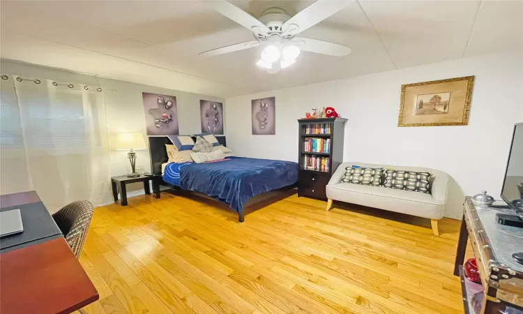 Bedroom with a ceiling fan and light wood-style floors