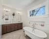 Full bath featuring double vanity and soaking tub