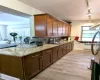 Kitchen with light stone counters, light wood-style flooring, and rail lighting