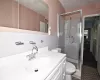 Bathroom featuring vanity, a shower stall, toilet, and tile walls