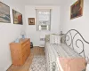 Bedroom featuring cooling unit, radiator, baseboards, and light wood-style floors