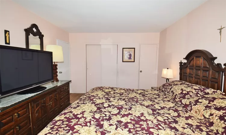 Bedroom featuring a closet and dark wood-style flooring