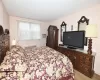 Bedroom featuring a wall mounted air conditioner, visible vents, and light wood-style flooring