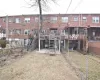 Back of property featuring stairway, brick siding, and fence private yard