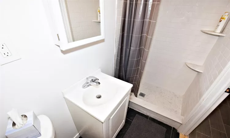 Bathroom featuring vanity and a shower stall