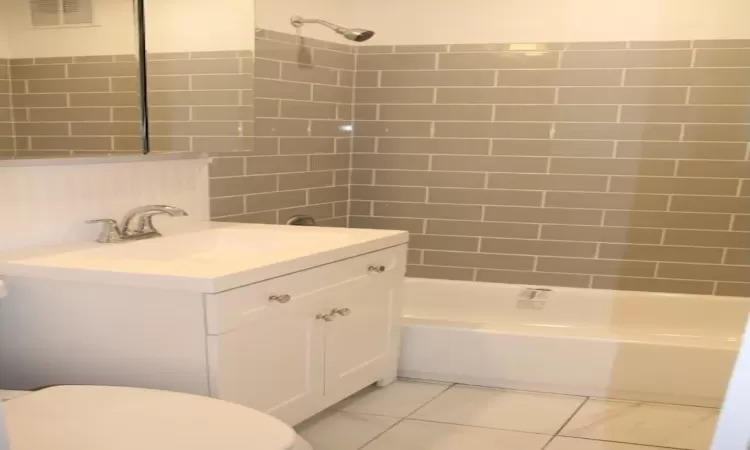 Full bathroom with visible vents, toilet, marble finish floor, shower / bath combination, and vanity