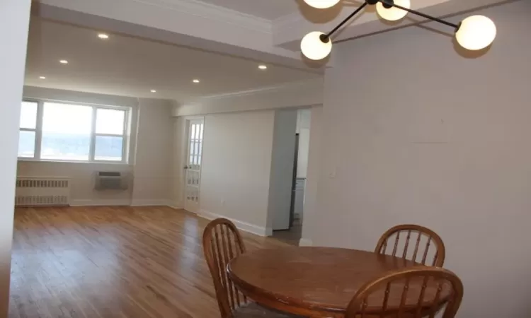 Dining area featuring ornamental molding, wood finished floors, recessed lighting, radiator, and baseboards