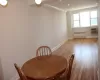 Dining space with radiator, baseboards, light wood finished floors, a wall mounted AC, and recessed lighting