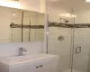 Full bathroom with a sink, visible vents, tasteful backsplash, and a shower stall