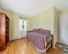 Bedroom featuring baseboards, a baseboard radiator, wood-type flooring, and a closet