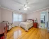 Bedroom with light wood-style flooring, ornamental molding, visible vents, and a baseboard radiator