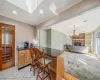 Kitchen with visible vents, dark stone counters, ornamental molding, a kitchen bar, and a brick fireplace