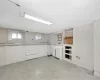 Kitchen featuring light floors, washer / dryer, and white cabinets