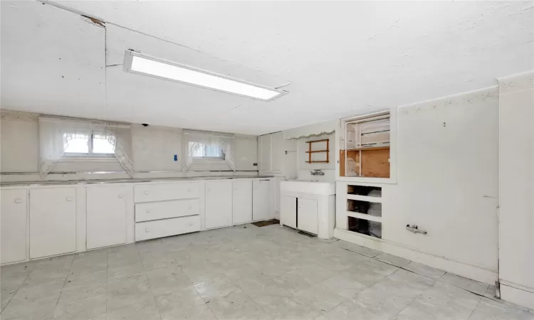 Kitchen featuring light floors, washer / dryer, and white cabinets