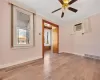 Empty room with visible vents, a wall unit AC, crown molding, light wood finished floors, and baseboards