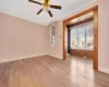 Spare room featuring ceiling fan, baseboards, ornamental molding, and light wood finished floors