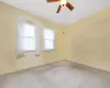 Empty room featuring ceiling fan and carpet floors