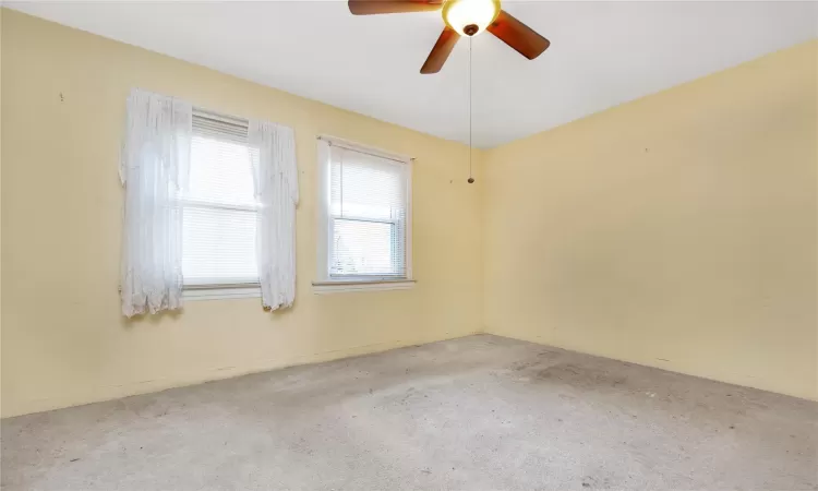 Empty room featuring ceiling fan and carpet floors