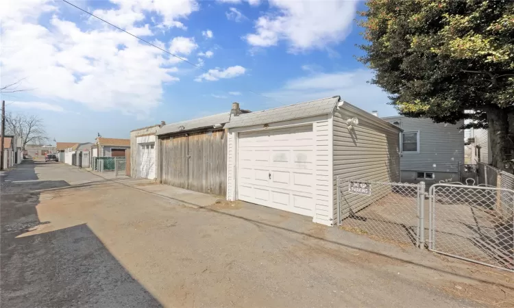 Garage featuring a gate and fence