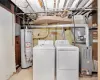 Washroom with water heater, laundry area, visible vents, and separate washer and dryer