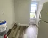 Laundry room featuring radiator, wood finished floors, and baseboards