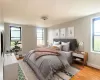 Bedroom featuring light wood-style floors, multiple windows, radiator, and baseboards