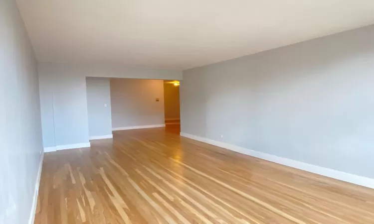 Empty room with light wood-type flooring and baseboards