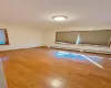 Spare room featuring a baseboard radiator, baseboards, and wood finished floors