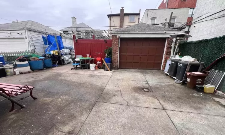 Garage featuring concrete driveway and fence