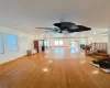 Unfurnished living room featuring stairway, baseboards, light wood-style flooring, and a wall mounted AC