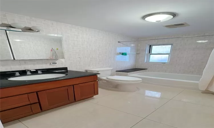 Full bathroom featuring visible vents, toilet, shower / tub combination, tile walls, and tile patterned flooring